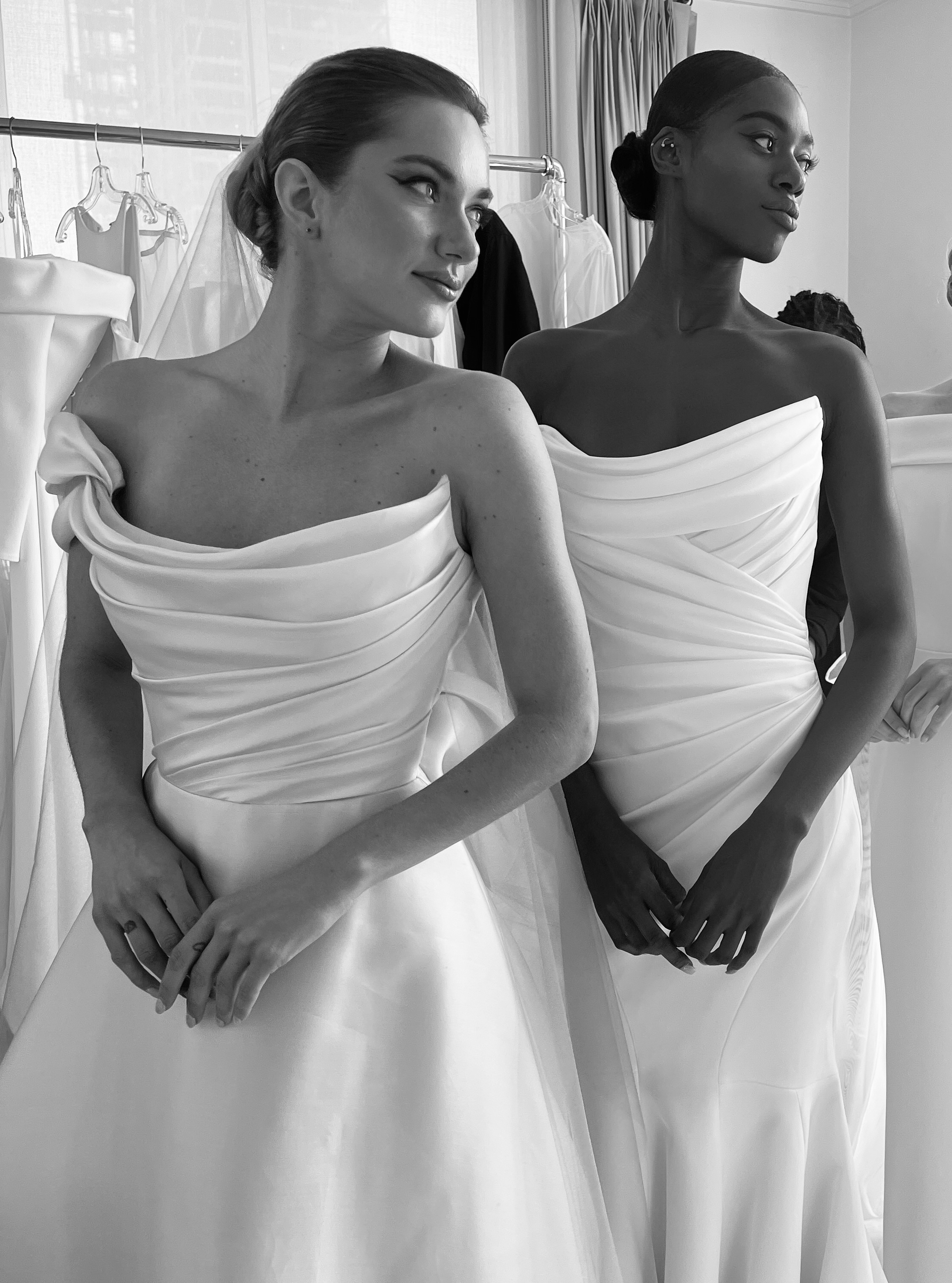 Two brides in strapless draped gowns, styled side by side