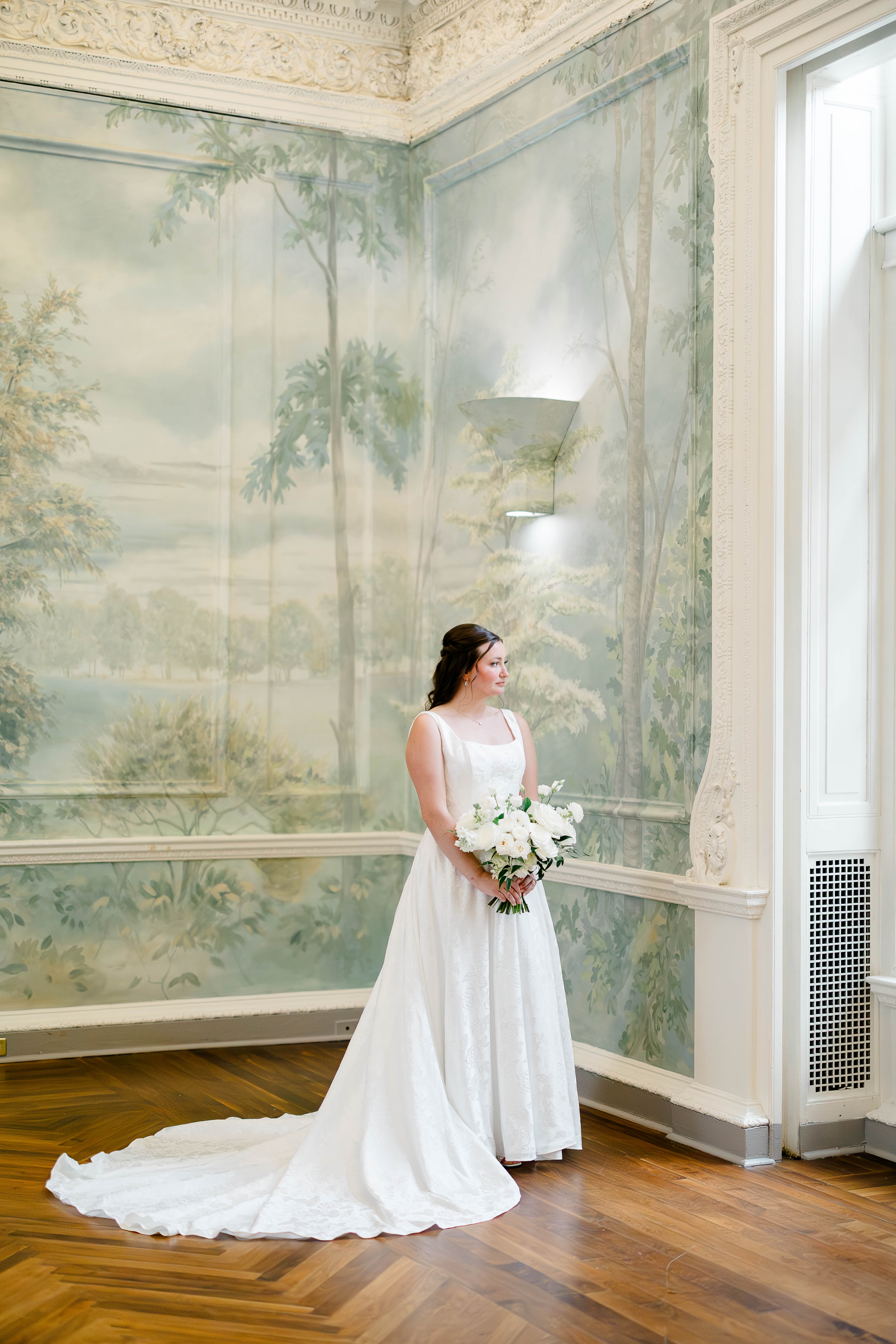 Full-length bridal portrait against a painted mural wall